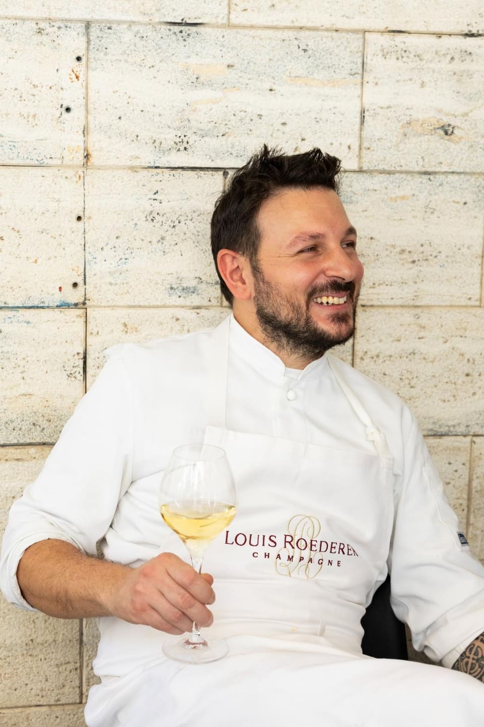 Lo chef Bruno Aversa del Gozzo con un calice di vino bianco