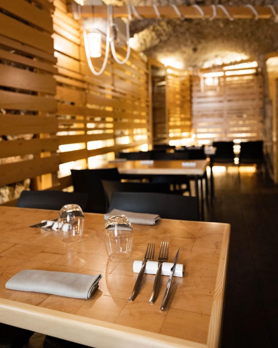 La sala del Gozzo nel centro storico di Salerno, tavoli in legno e pareti in pietra